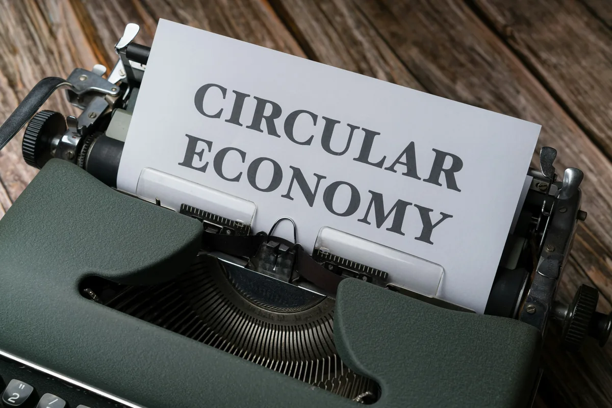 a close up of a typewriter with a paper that reads circular economy