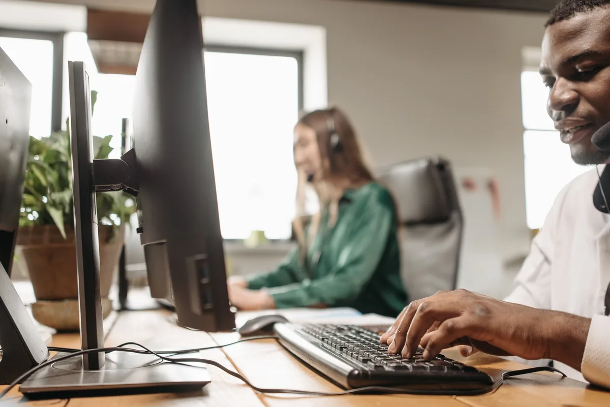 Customer support agents working at a busy call center with focus on diversity and teamwork.